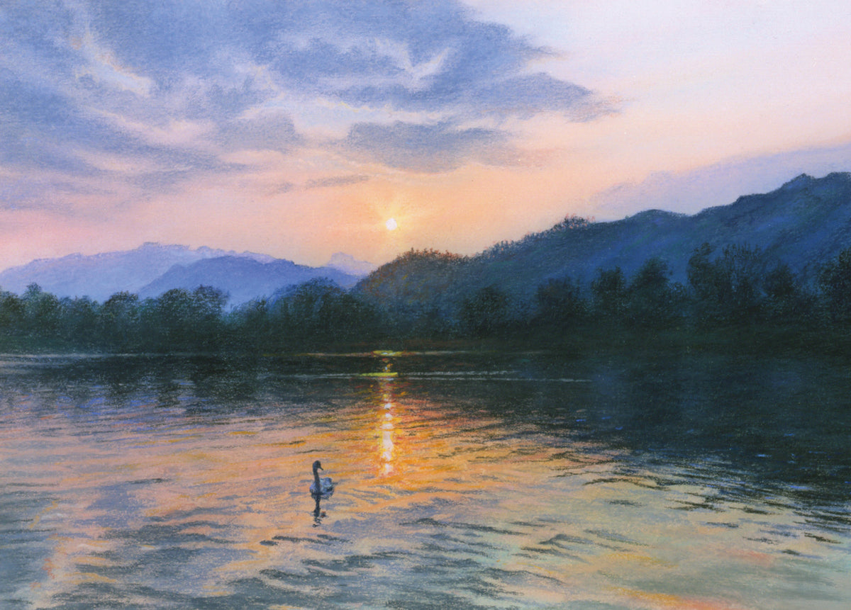 Person standing in a lake at sunset with mountains in the background